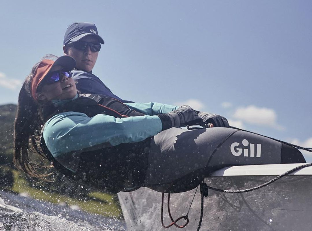 Man en vrouwen op het water in dinghy zeilkleding van Gill