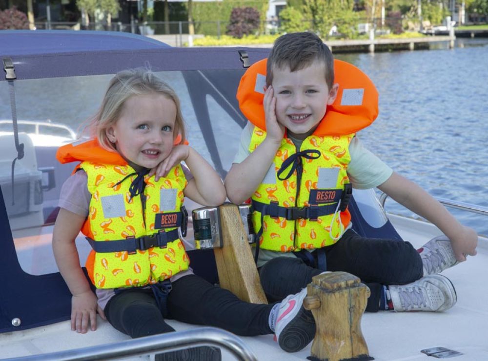 Jongen en meisje op de boot met Besto kinder reddingsvesten aan