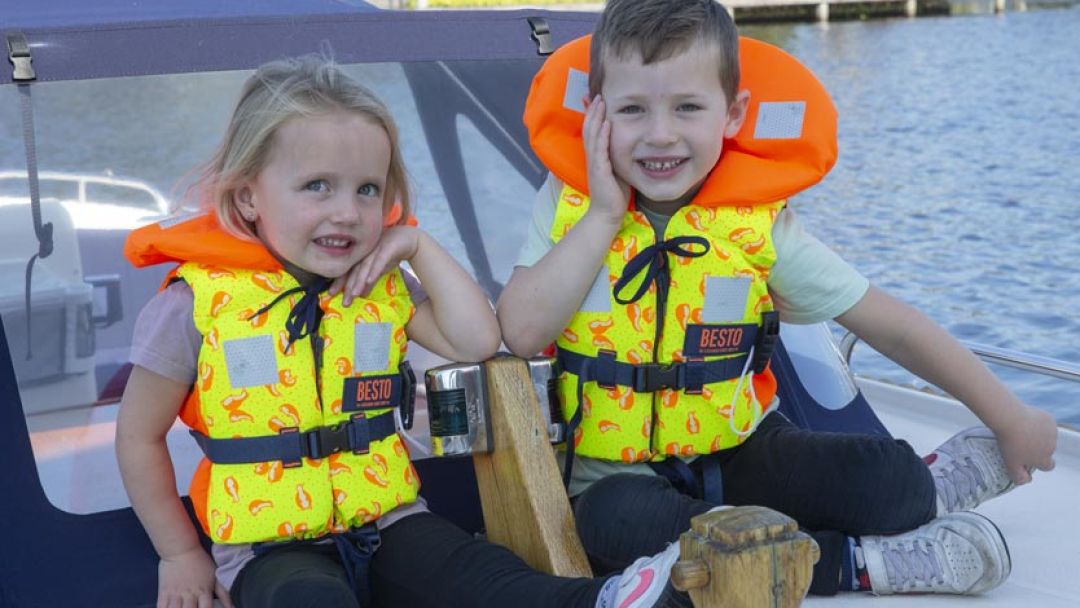 Jongen en meisje op de boot met Besto kinder reddingsvesten aan